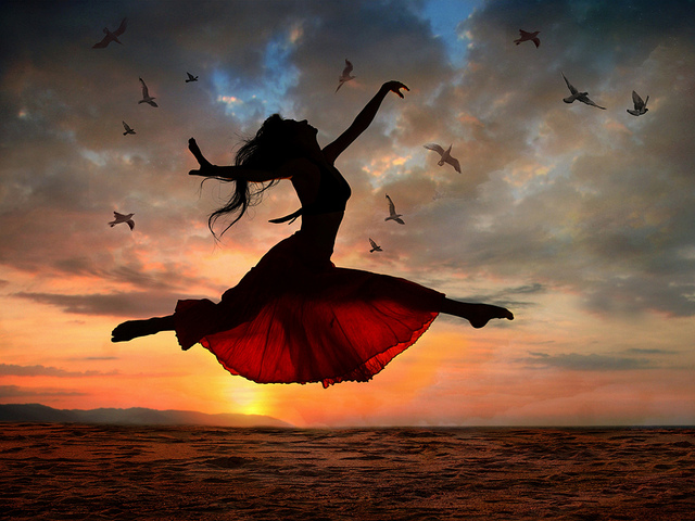 Jumping woman at sunset